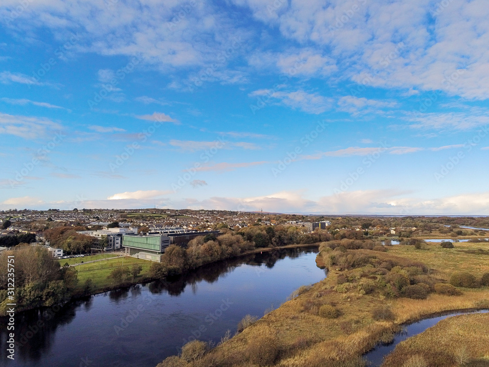 Obraz premium River Corrib in Galway city by NUI research facility. Warm sunny day blue sky, Aerial drone, view.