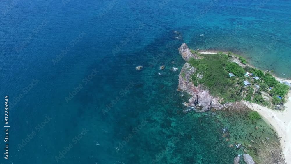 Coastal aerial flight along rocky cliffs of island with underwater geology visible Coastal aerial flight along rocky cliffs of island with underwater geology visible
