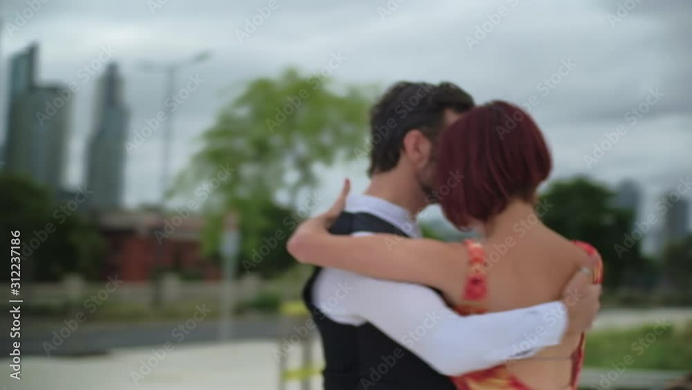 Orbital shot of two passionate dance partners doing a tango coreography in the streets of Puerto Madero, Buenos Aires Orbital shot of two passionate dance partners doing a tango coreography in the streets of Puerto Madero, Buenos Aires