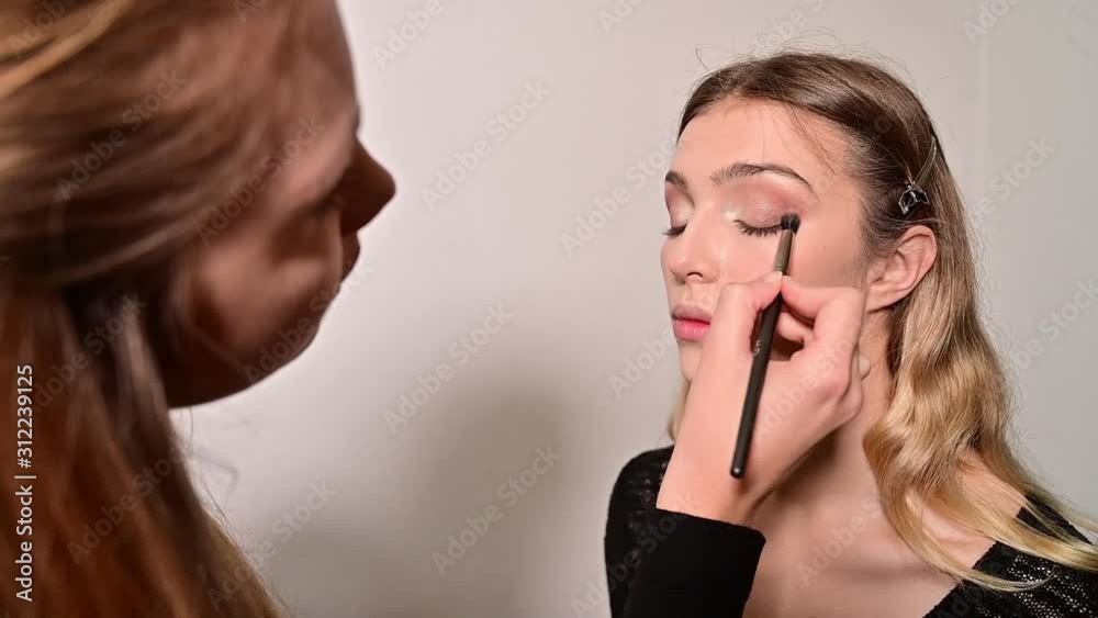 Makeup artist applying makeup on pretty womans face Makeup artist applying makeup on pretty womans face