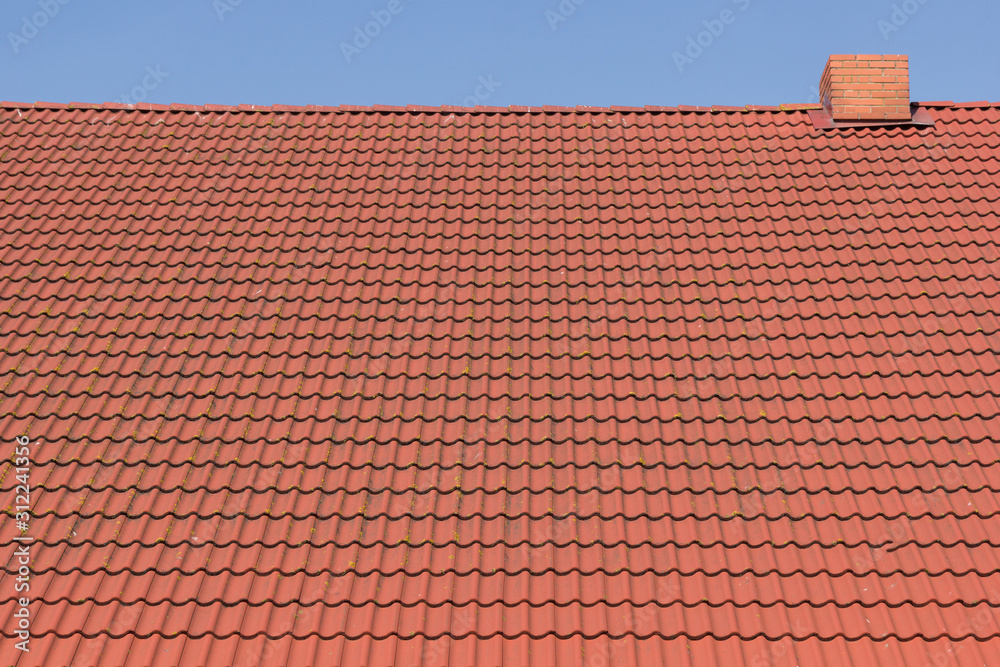 red tile roof with chimney against blue sky red tile roof with chimney against blue sky