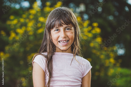 Portrait of smiling beautiful young girl at farm. Girl at farm in summer day. Gardening activity. Brazilian girl.