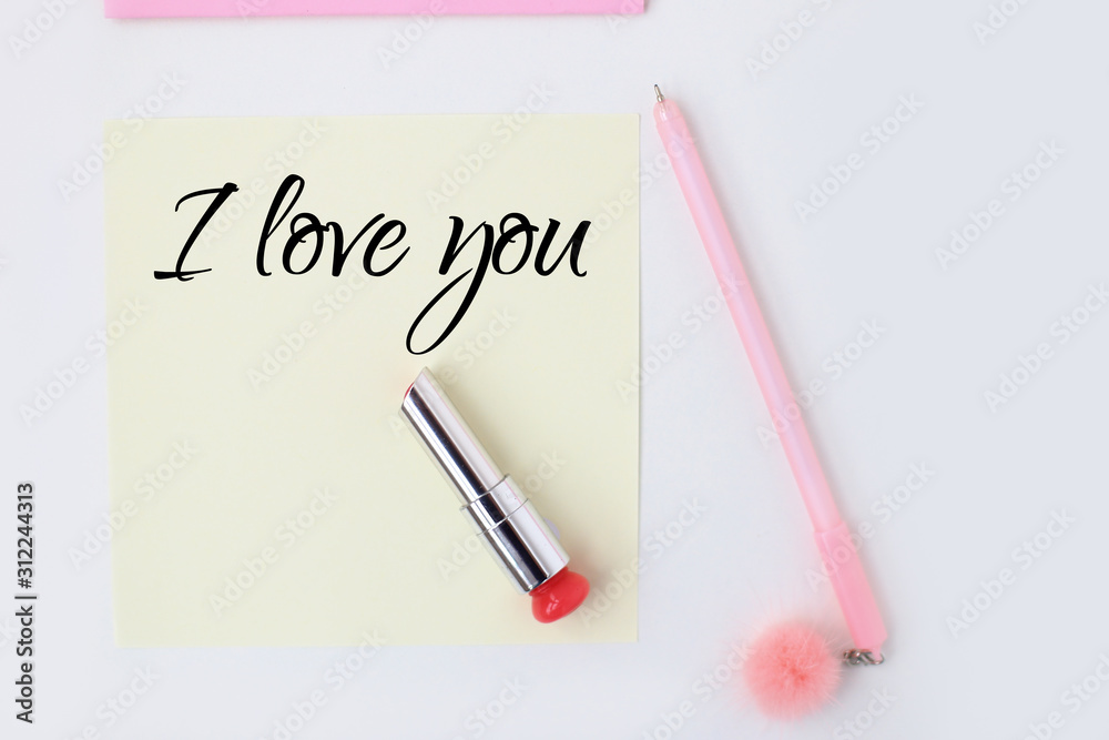 Flat lay: yellow paper, pink pen, pompom, lipstick, confetti hearts, lip print, i love you text. Making postcard in envelope for Valentine's Day.Do it yourself.Photo from the series Flat lay: yellow paper, pink pen, pompom, lipstick, confetti hearts, lip print, i love you text. Making postcard in envelope for Valentine's Day.Do it yourself.Photo from the series