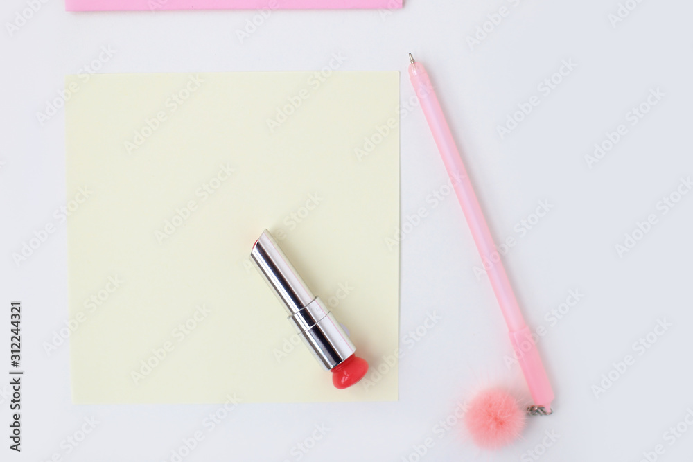 Flat lay: yellow paper, pink envelope, pen, pompom, lipstick. Making postcard in envelope for Valentine's Day.Do it yourself.Photo from the Flat lay: yellow paper, pink envelope, pen, pompom, lipstick. Making postcard in envelope for Valentine's Day.Do it yourself.Photo from the