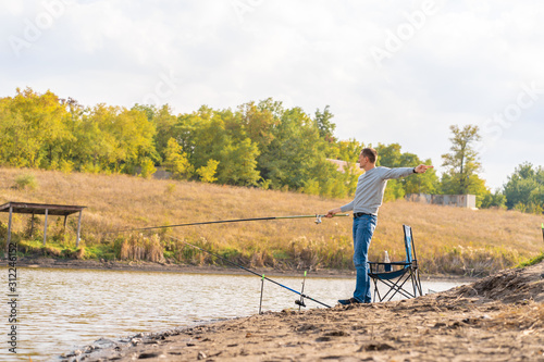 Man relaxing and fishing by lakeside a