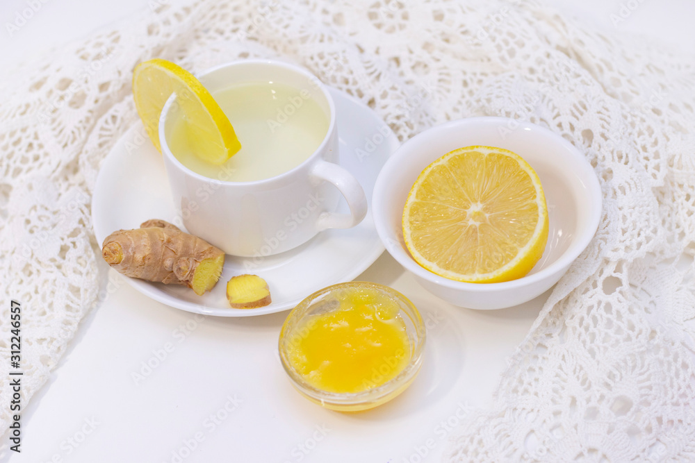 ginger tea with lemon and honey. Tea for immunity, a cold drink. ginger tea in a white cup on a white background. The concept of winter, health, immunity. A healthy detox drink.