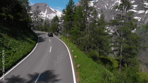Aerial view Grossglockner Hochalpenstrasse, Alpine Road in Austria. Pine forest, sunny summer day, blue sky. Motorcyclists and travelers road. vacation and adventure, hiking and active lifestyle