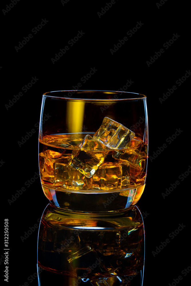 glass of scotch whiskey with ice on black background