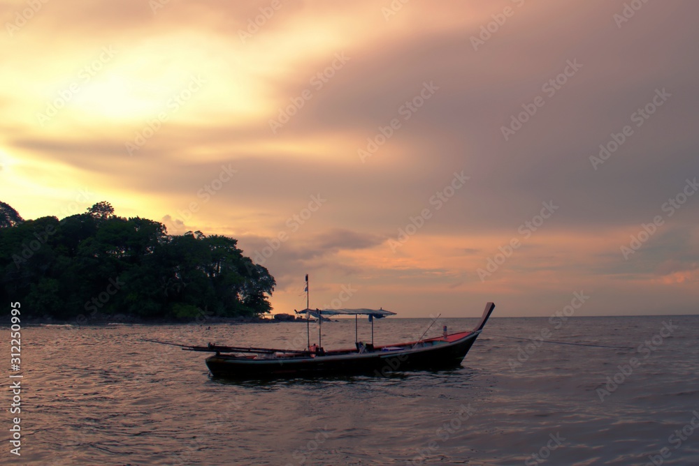 Naklejka premium Fishing boat at sunset in Phuket, Thailand.