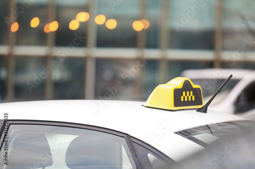 Taxi cab with yellow sign on city street, closeup