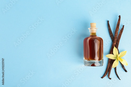 Flat lay composition with vanilla extract on light blue background. Space for text photo