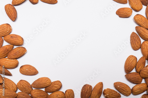 Whole almond nuts on the white background. Healthy vegetarian snack. Close-up photo. Space for your text.