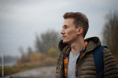 casual portrait of a young, handsome man taken outside