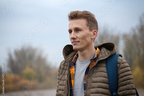casual portrait of a young, handsome student taken outside