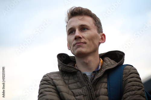casual portrait of a young, handsome man taken outside