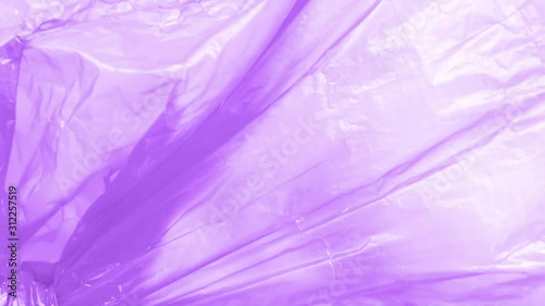 Purple plastic bag with garbage to recycle outdoors. Wind blowing and moving surface of the bag. Texture