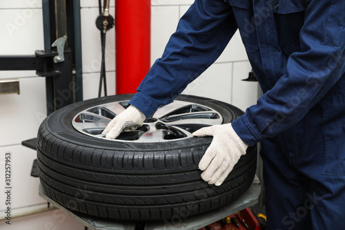 Принти на полотні Man working with tire fitting machine at car service, closeup