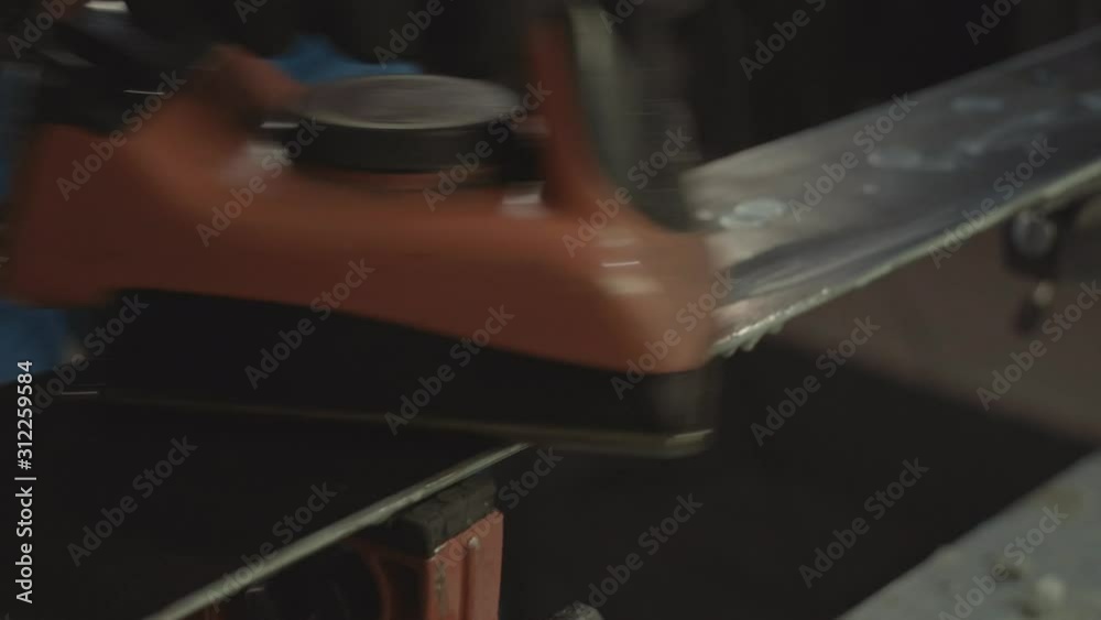 Applying hot wax to ski base with iron. Applying Ski Wax To Ski Base. Ski base tuning. Ski wax iron and wax bars. Ski service and repair. repairman in workshop ski service. Man Waxing Ski In Workshop Applying hot wax to ski base with iron. Applying Ski Wax To Ski Base. Ski base tuning. Ski wax iron and wax bars. Ski service and repair. repairman in workshop ski service. Man Waxing Ski In Workshop