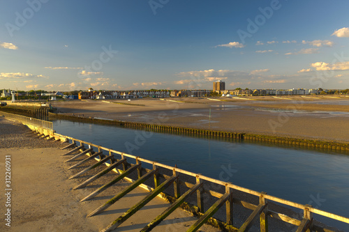 View of River Arun entering the sea at low tide with Littlehampton in the background on a beautiful warm summers day.