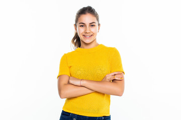 Beautiful teen girl student with confident expression, keeps arms folded. Portrait of smiling teenager isolated on white background.