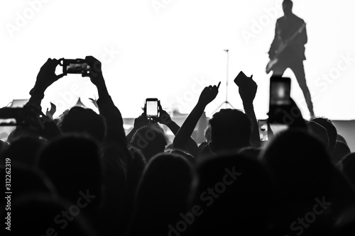  people having fun and dancing with their hands to the sky during a live music concert