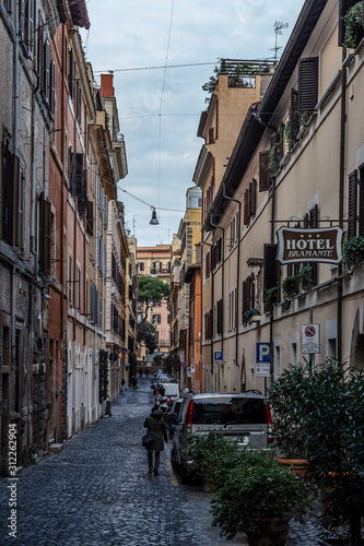Fototapeta Naklejka Na Ścianę i Meble -  Streets of historic center of Rome, building, local people and tourists walking in city on narrow streets of old town in Rome, Italy