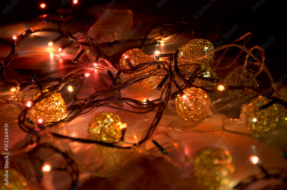 Garland with colored lights close-up lies on a flat surface. Selective focus. Garland with colored lights close-up lies on a flat surface. Selective focus.