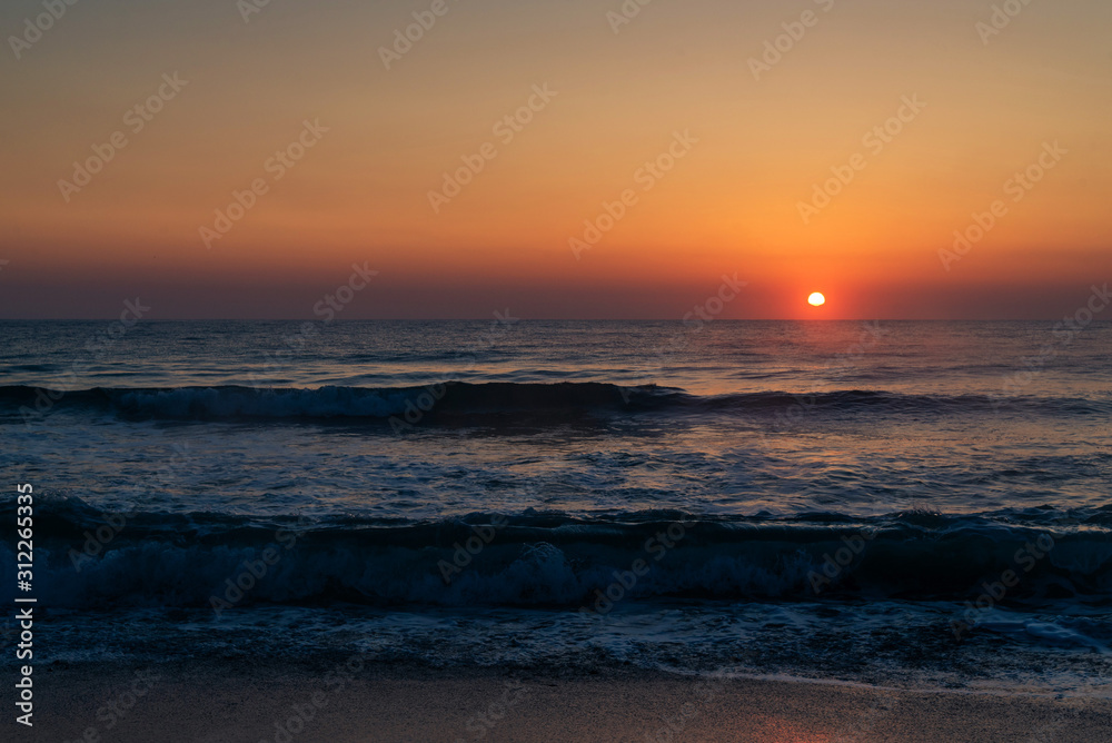 Beautiful sunrise on the sea coast in a storm