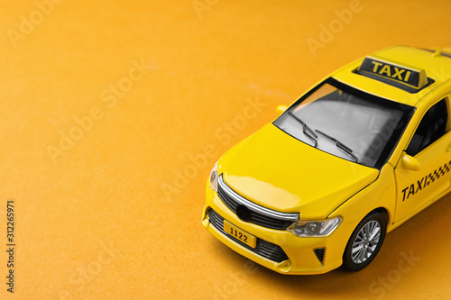 Foto Yellow taxi car model on orange background. Space for text