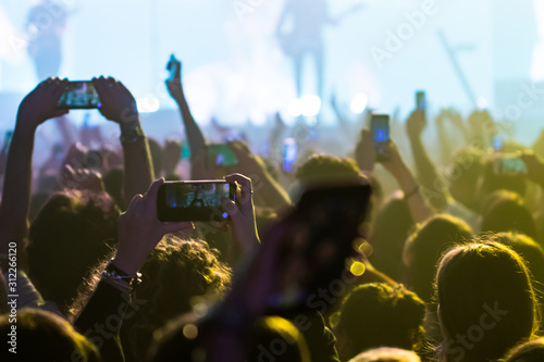  people having fun and dancing with their hands to the sky during a live music concert