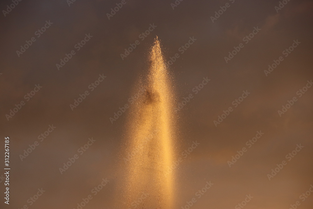 Water of a fountain illuminated by the sunlight during sunset Water of a fountain illuminated by the sunlight during sunset