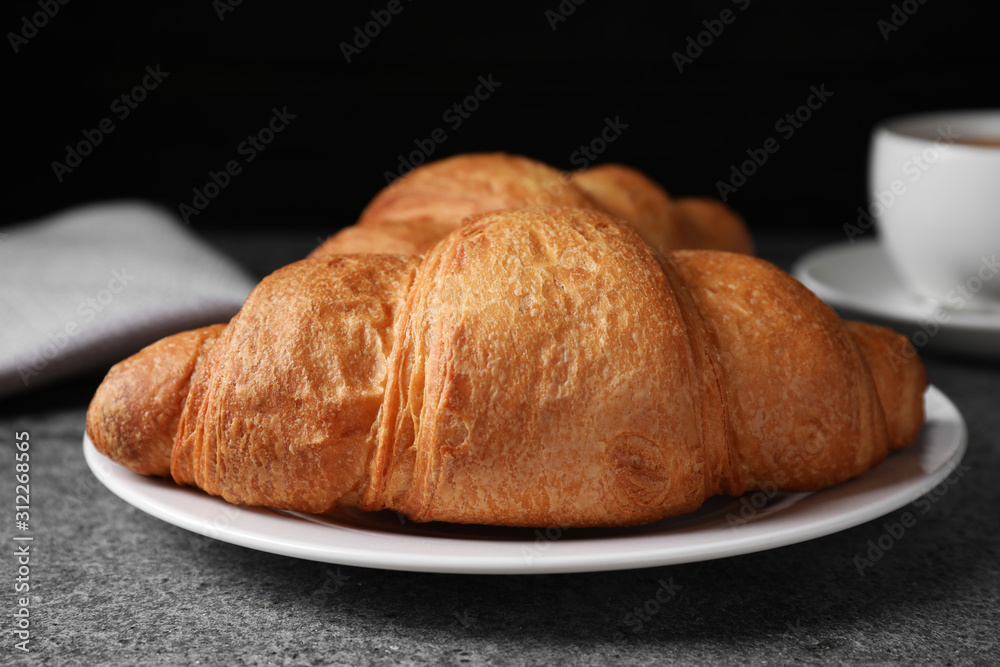 Tasty fresh croissants on grey table, closeup
