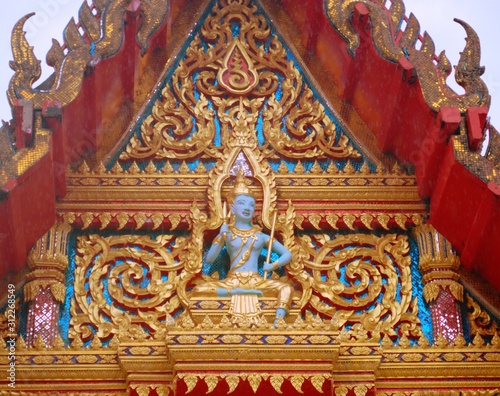 Sculpture of a buddhist deity at Wat Chaithararam temple complex in Phuket, Thailand.