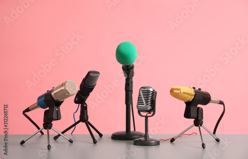 Microphones on table against pink background. Journalist's work