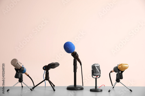 Different microphones on light grey table. Journalist's work