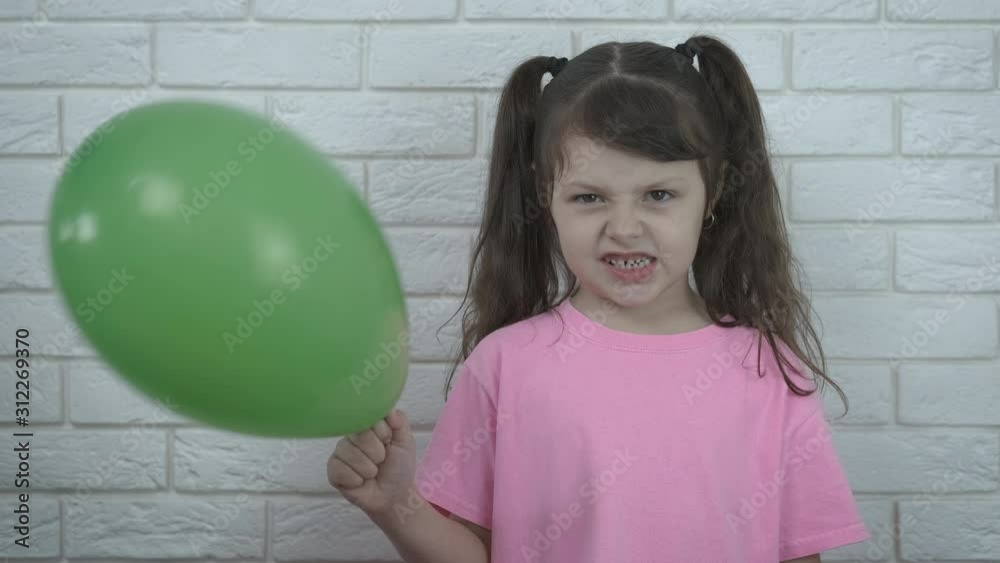 Sad birthday with balloon. Angry little girl with a balloon. Sad birthday with balloon. Angry little girl with a balloon.