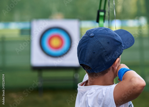 Fotobehang Young boy aims at a target with his bows and arrows