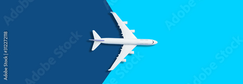 Flat lay design of travel concept with plane on blue background with copy space