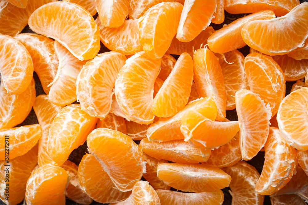 Slices of ripe tangerines on a dark background flat lay. Slices of ripe tangerines on a dark background flat lay.