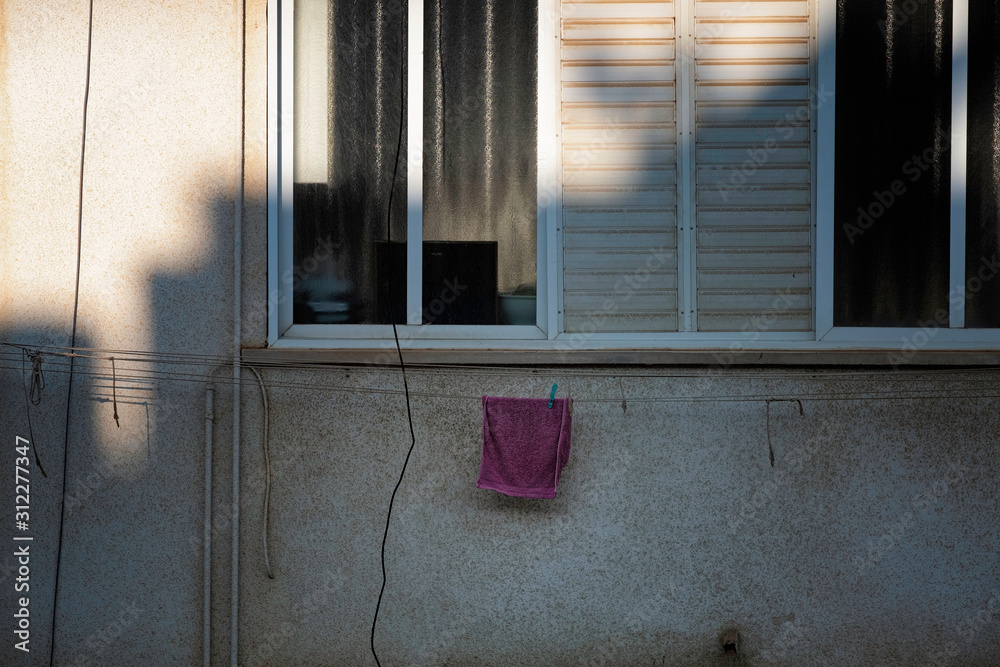 Mediteranean style house with open window and towel hanging to dry.