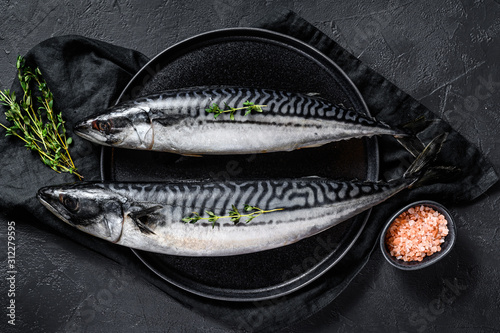 Mackerel fish with thyme and pink salt. Fresh seafood. Black background. Top view