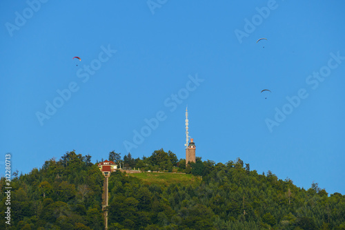 Foto Blick auf den historischen Turm auf dem Merkur in Baden-Baden mit Gleitschirmfli