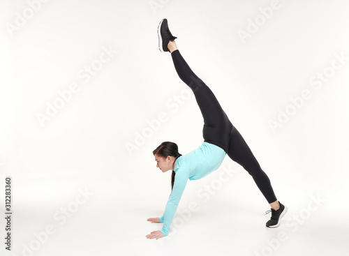 Young athletic woman making yoga and gymnastics stretching exercises isolated on white 
