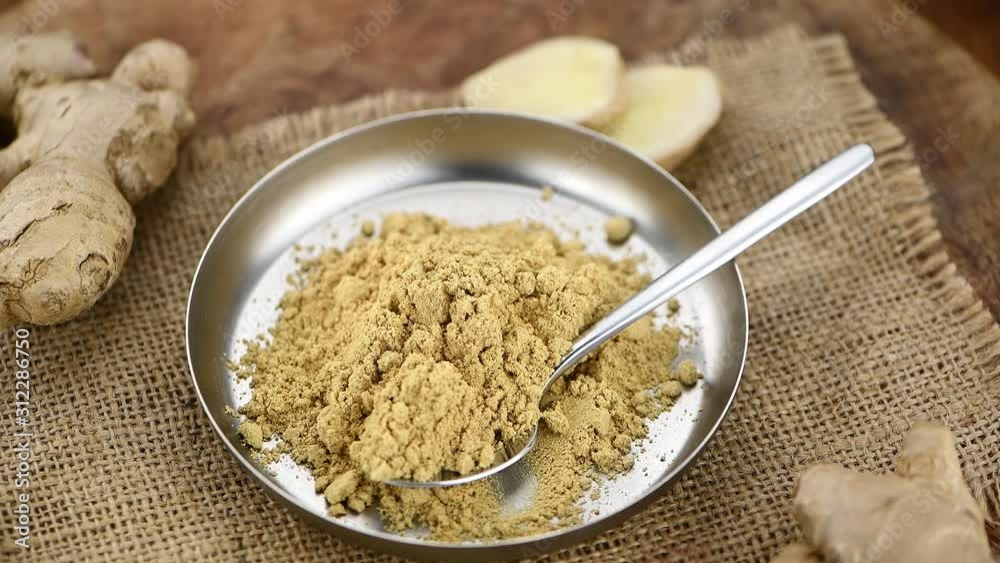 Ginger powder on an old wooden plate (seamless loopable; selective focus) Ginger powder on an old wooden plate (seamless loopable; selective focus)