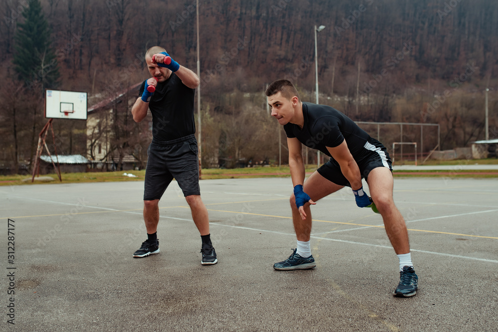 Two athlete working training with kettlebell and dumbbells