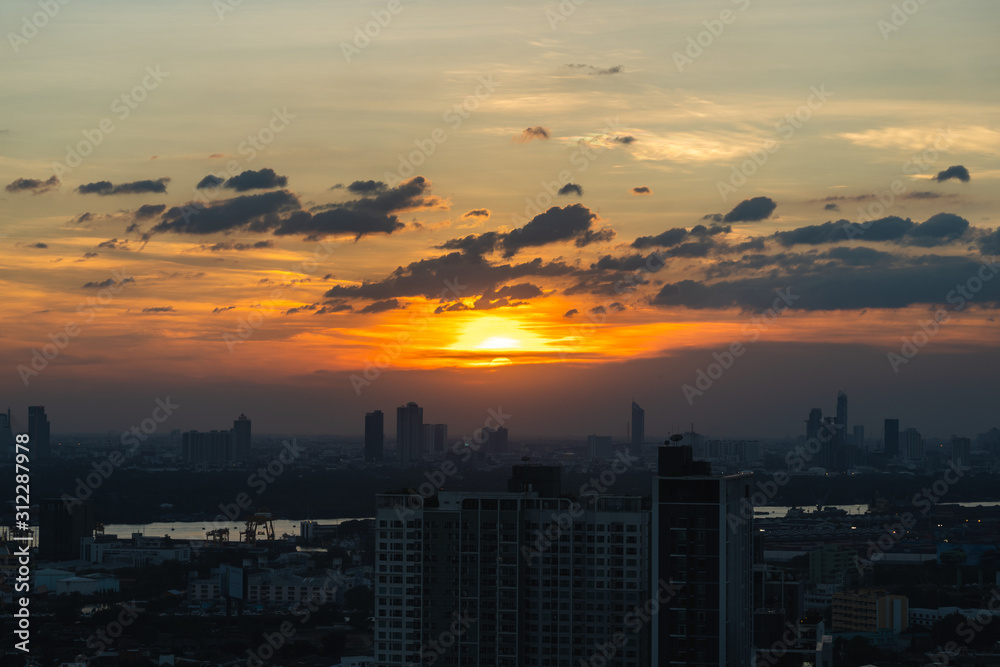 Fototapeta premium Sunset city scenery with sun and building in Bangkok; Thailand