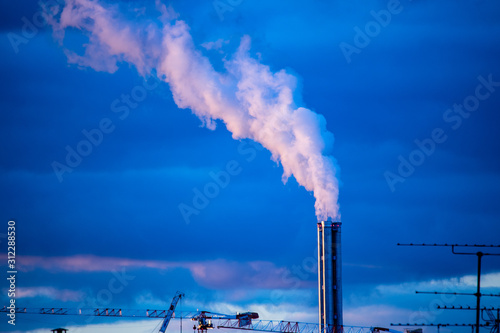 Atmospheric Air Pollution From Industrial Smoke billowing from Smoking pipes and cranes beside smoking pipes, ecology problems paris france