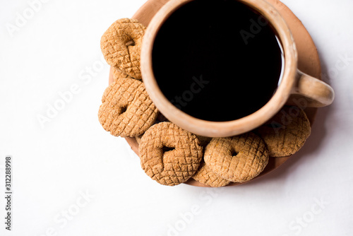 Rosquetes, a sweet made of pinol, on a traditional coffee cup made of clay.  Nicaraguan breakfast/snack. No people. photo