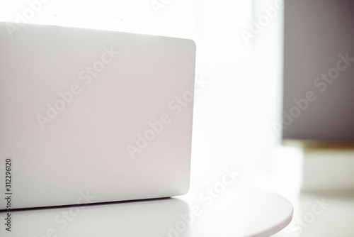 Laptop on a white table with space on the right. No people