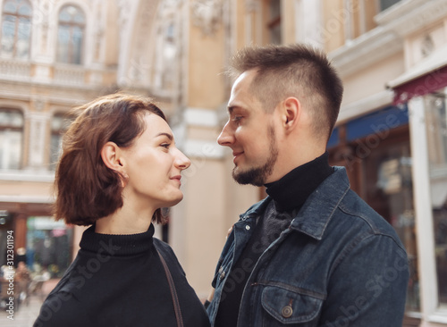 Young couple in love hugs and spend time together in the city against the backdrop of urban architecture.